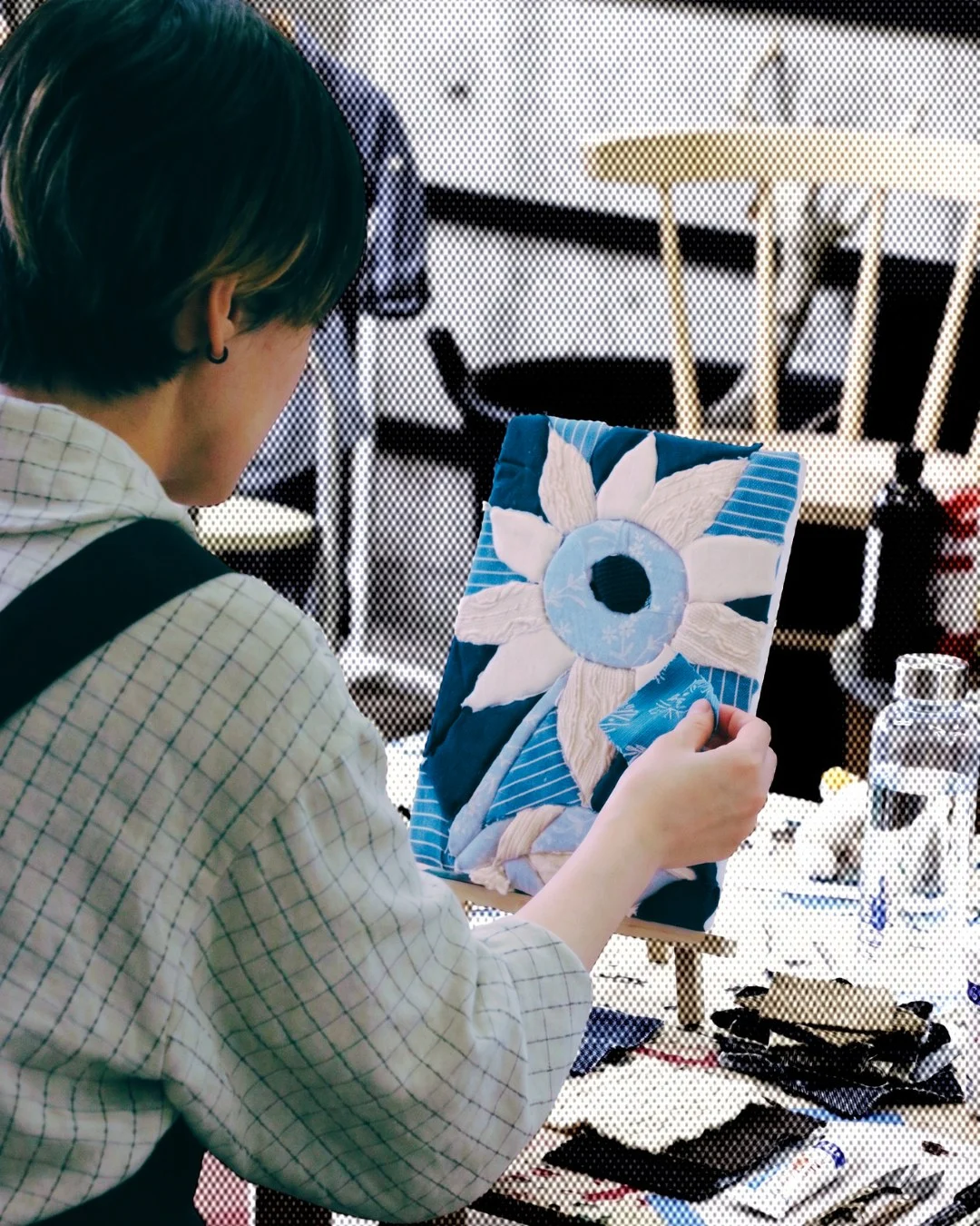 布の端切れを貼り重ねてつくったファブリックモザイクアートの作品。青と白のはぎれで大きな花が描かれている
