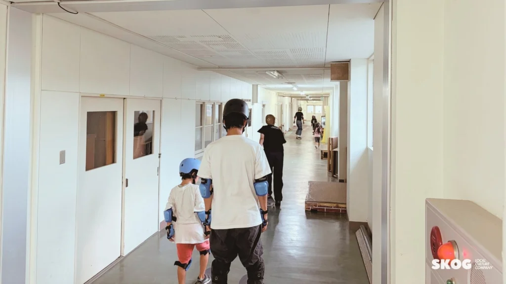 廊下の直線を、子どもと並んで進む保護者